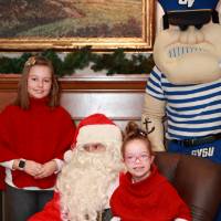 Two sisters with Santa & Louie at the event.